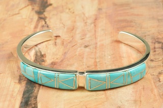 Beautiful Bracelet featuring Genuine Sleeping Beauty Turquoise inlaid between ribbons of Sterling Silver. Precision channel inlay. Heavy Gauge Sterling Silver Bracelet  Designed by Navajo Artist Calvin Begay. Signed by the artist. 